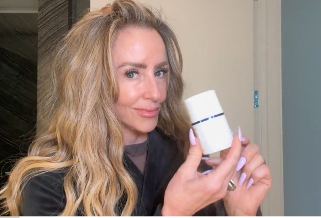Chalene Johnson holding a bottle of Midi Health estrogen face cream