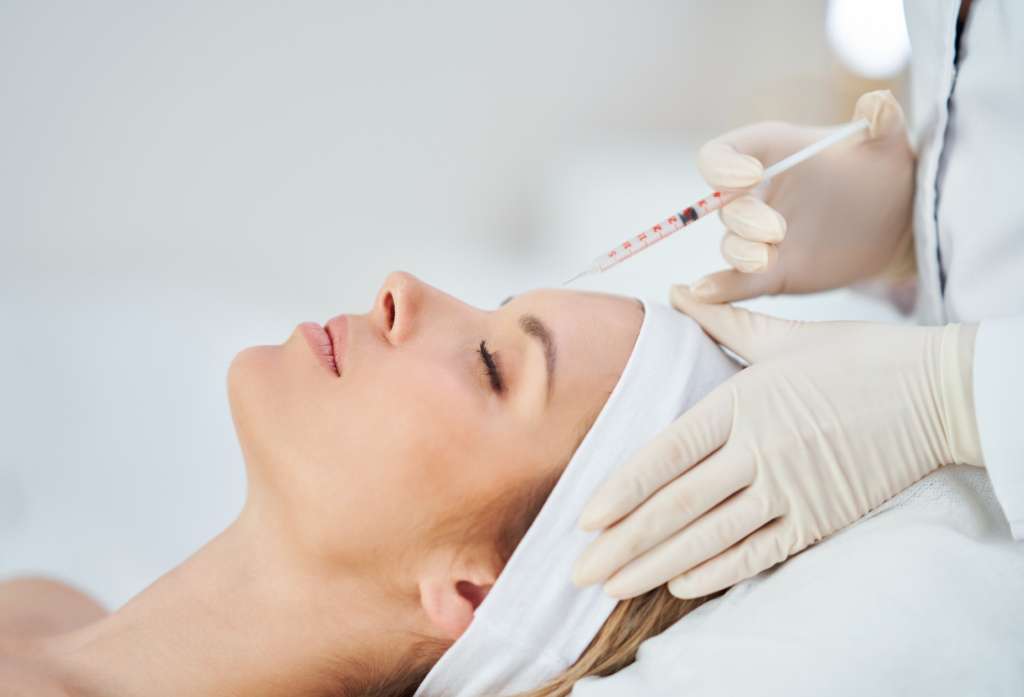 Woman receiving a Botox or filler facial injection from a gloved injector in a clinical medspa setting